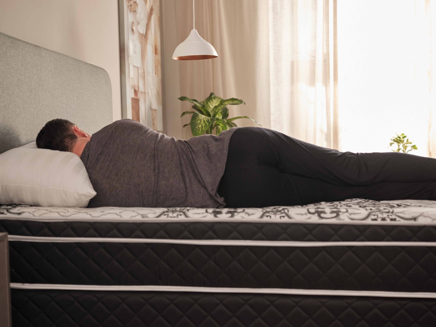 pessoa deitada em um colchão para dor nas costas com a coluna alinhada